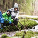 Des enfants découvrent un ruisseau en forêt lors d'une randonnée